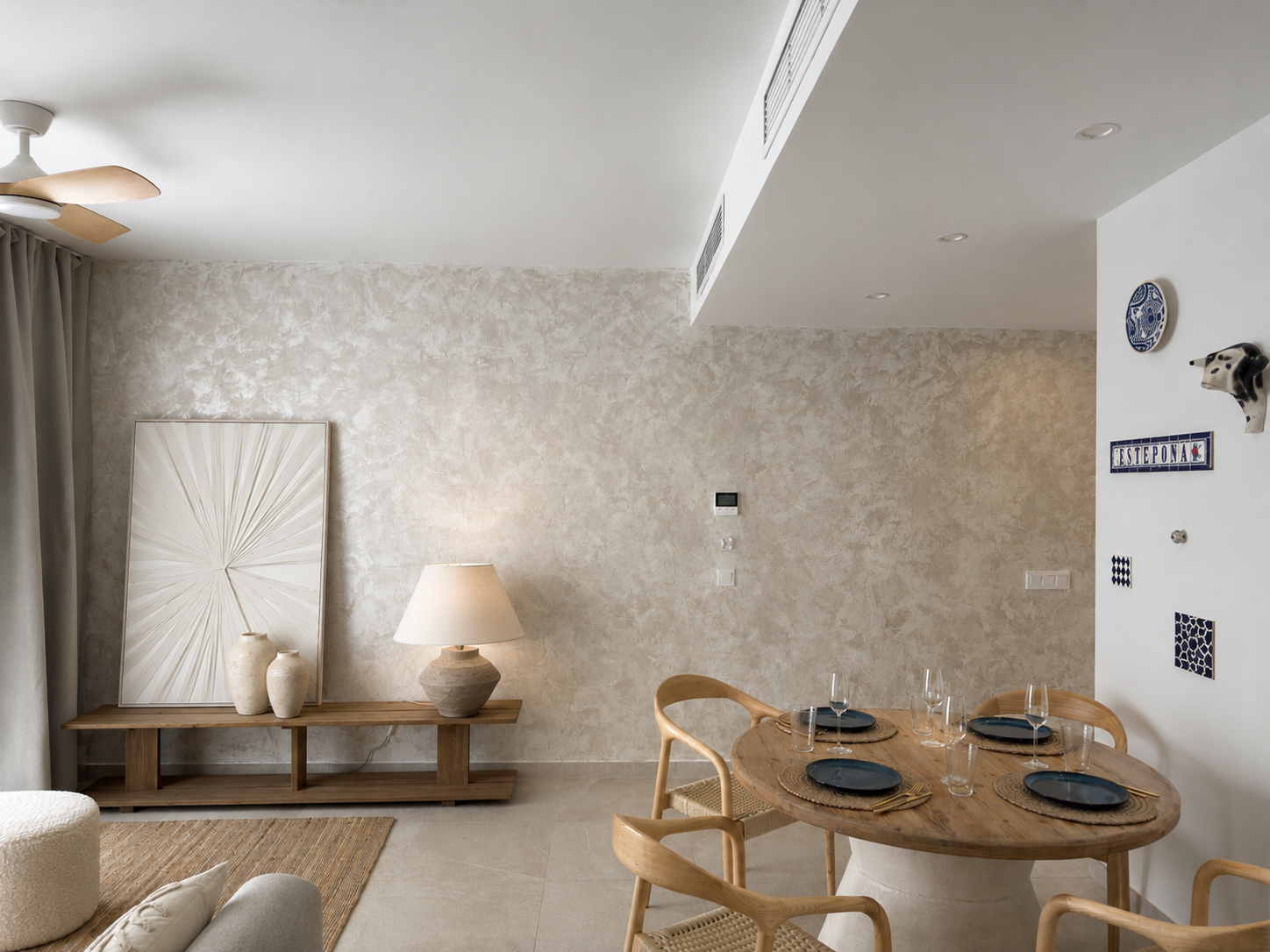 Neutral living and dining area with textured plaster wall and oak furniture